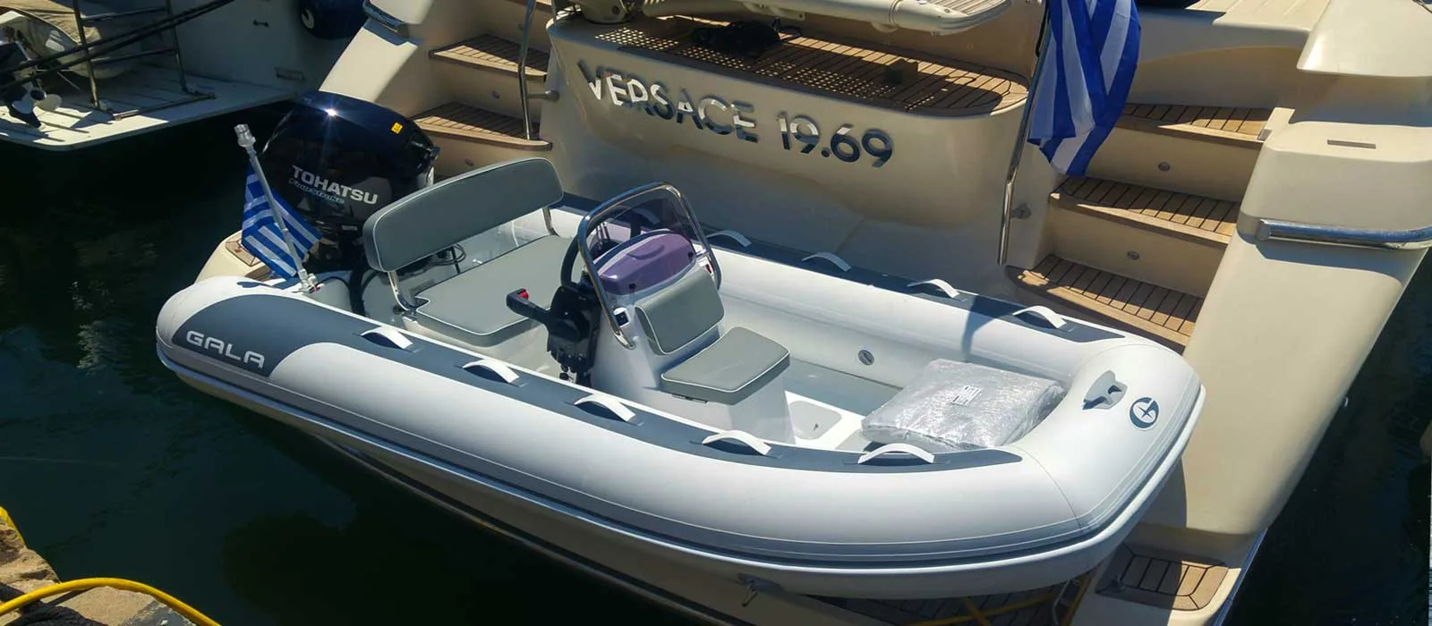 Gala Atlantis Deluxe tender docked beside a yacht